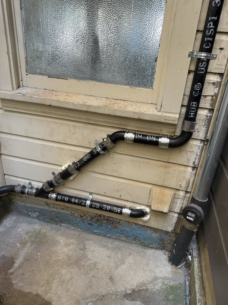 Cast iron drain and vent stack installation along exterior wall